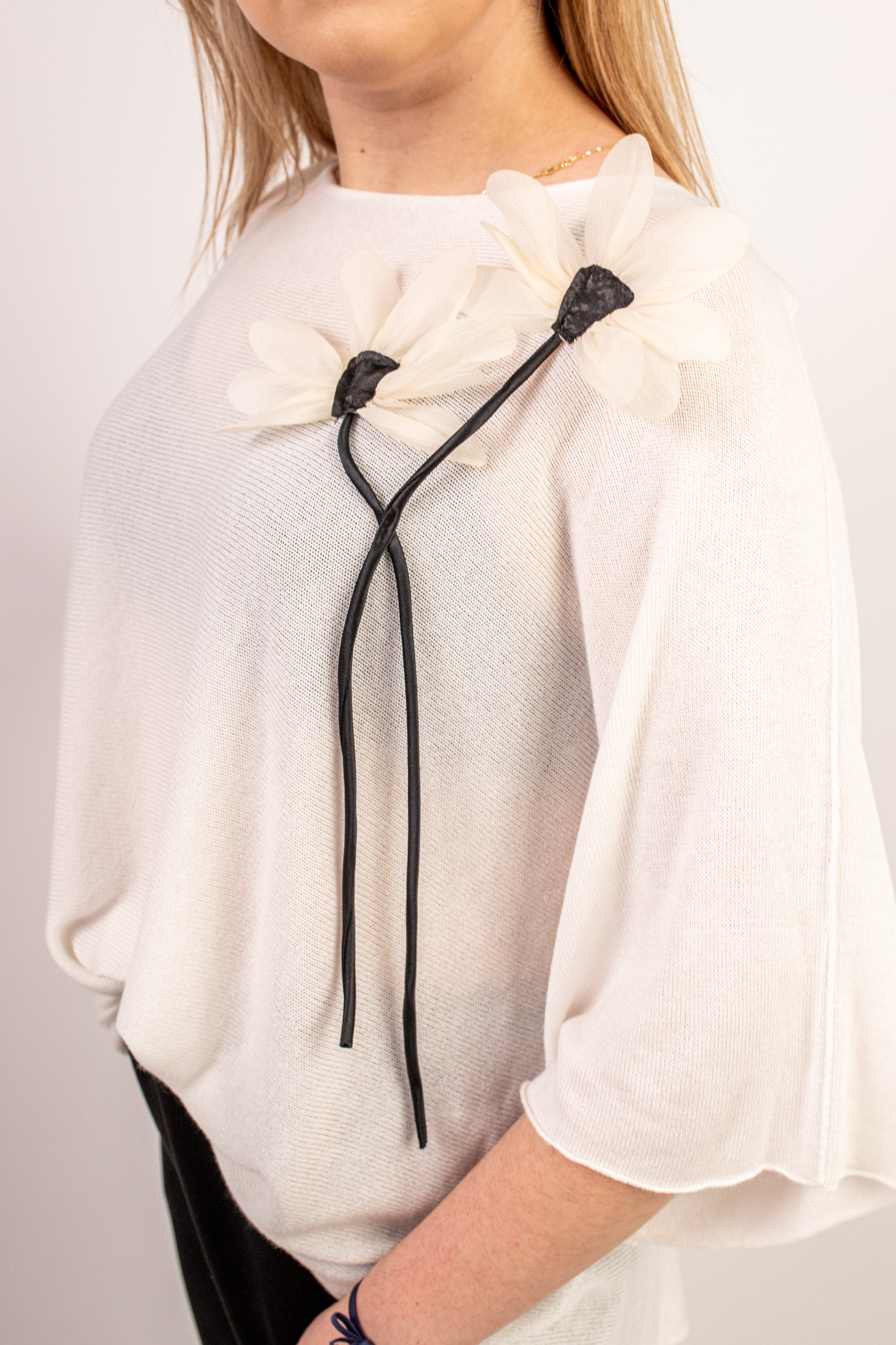 Włoski elegancki oversize’owy sweter z ozdobnym kwiatem Krem